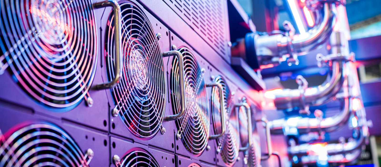 Server cooling fans and liquid-cooling pipes in a data centre, lit in purple and red